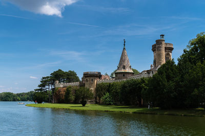 View of building by river against sky