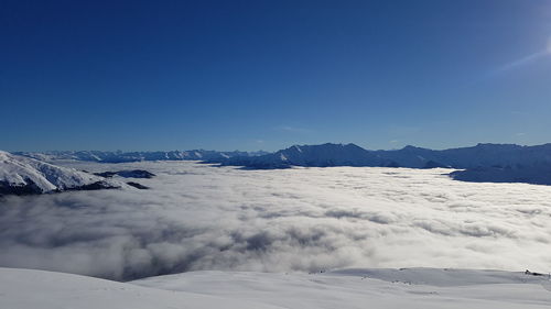 Scenic view of snowcapped mountains against blue sky