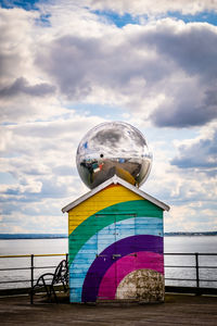 Lighthouse by sea against sky