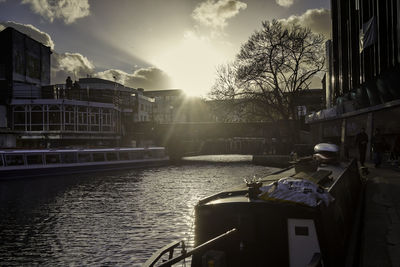 Buildings by river against sky in city