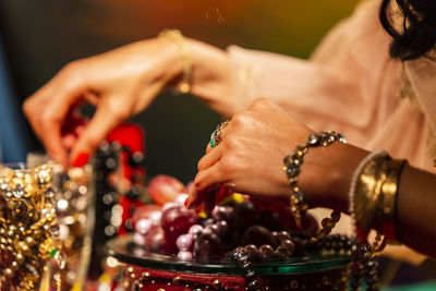 Midsection of woman with jewelry on table