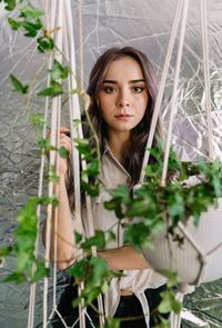 Portrait of a beautiful young woman against potted plants in room