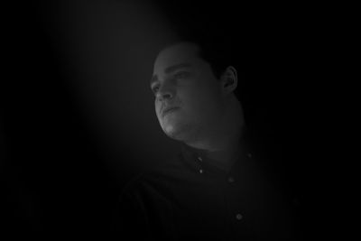 Close-up of man against black background