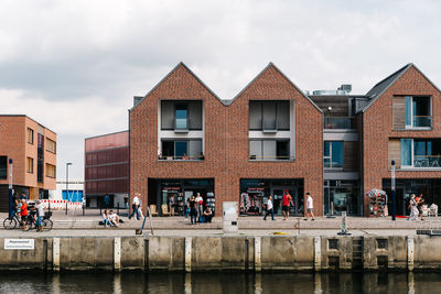 Group of people in city buildings against sky