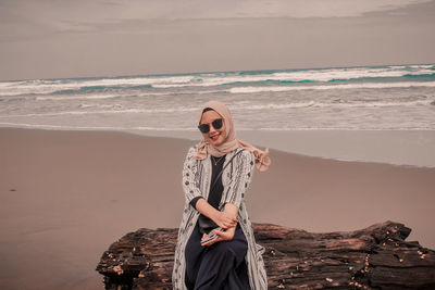 Woman standing on beach against sky