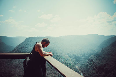 Man standing at observation point against mountain range