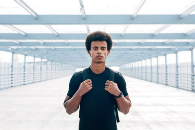 Portrait of young man standing on bridge