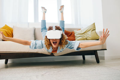 Midsection of woman sitting on sofa at home