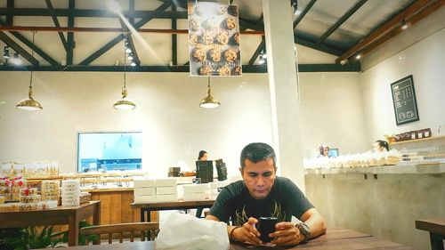 Portrait of man using mobile phone in restaurant