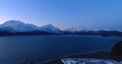 Scenic view of snowcapped mountains against clear blue sky