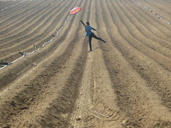 Woman holding umbrella on field