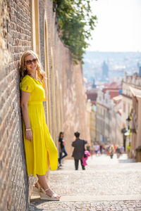 Woman in yellow dress traveling in city