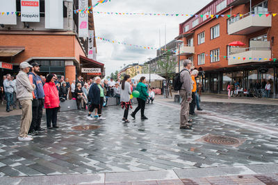 People on street in city against sky