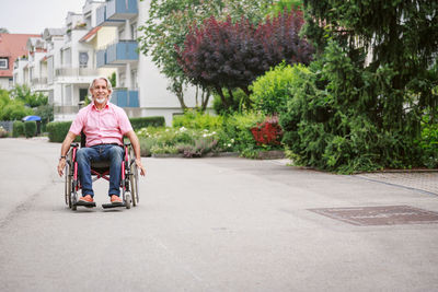 Portrait of man sitting on road in city