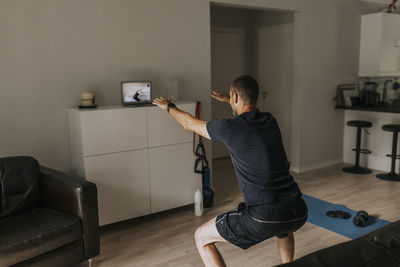 Man doing squats at home