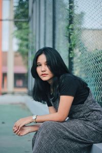 Beautiful young woman sitting outdoors