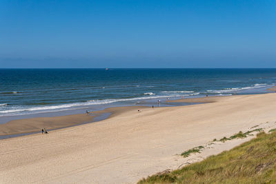 Scenic view of beach against clear blue sky