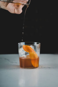 Close-up of hand pouring drink in glass