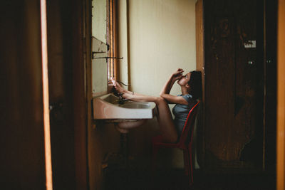 Side view of young woman at home