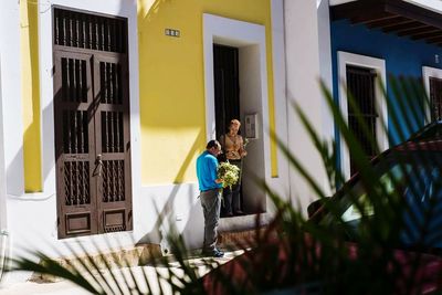 Rear view of people walking outside house