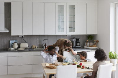 Family sitting at table and eating breakfast