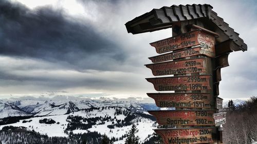 Sign boards on structure against snow covered landscape