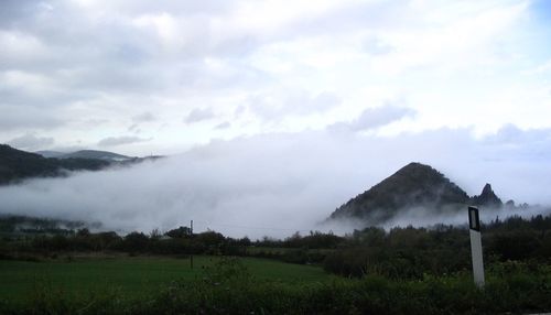 Scenic view of field and mountains against sky