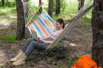 People sitting on hammock in forest