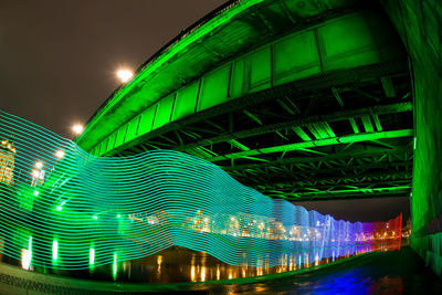 Low angle view of illuminated bridge against sky at night