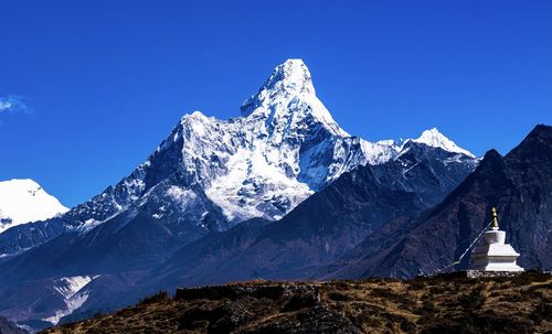 Scenic view of snowcapped mountains against clear blue sky