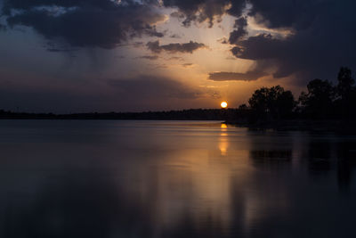 Scenic view of lake against sky at sunset