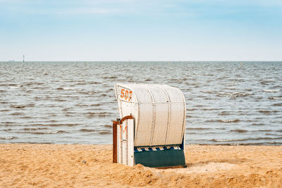 Sandy beach and typical hooded beach chairs in cuxhaven in the north sea coast a cloudy day, summer