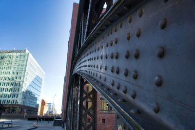 Low angle view of bridge and buildings against sky