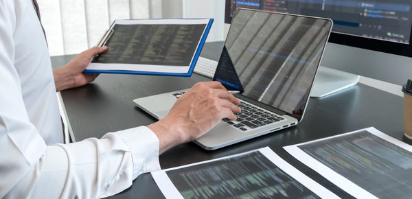 Midsection of doctor using laptop on table