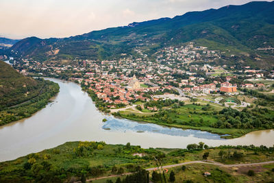 High angle view of townscape by mountain against sky