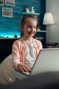 Portrait of smiling girl sitting at home