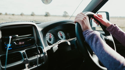 Midsection of man using smart phone in car