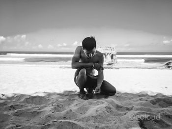 Full length of man sitting on beach