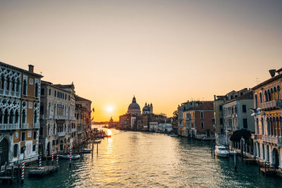 Grand canal and santa maria della salute against sky in city during sunset