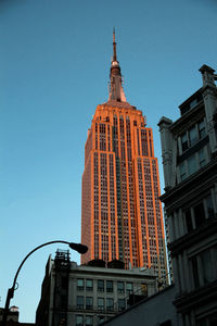 Low angle view of skyscrapers against blue sky