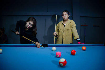 Portrait of woman playing pool