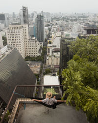 High angle view of swimming pool by buildings in city