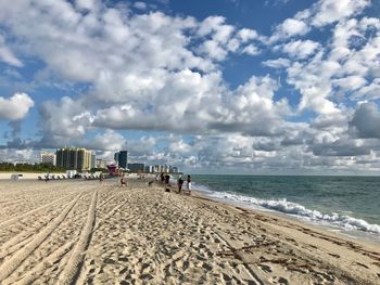 People on beach against sky