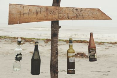 Close-up of text on bottle against sea