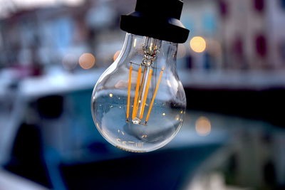 Close-up of light bulb hanging outdoors