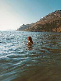 Rear view of woman swimming in sea