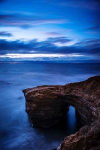 Rock formation in sea against sky