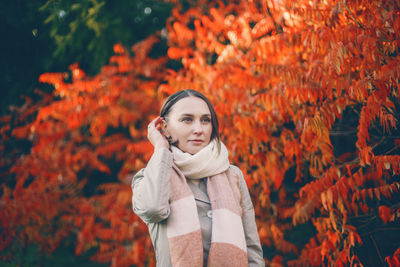 Portrait of beautiful young woman standing in autumn