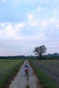 Person riding motorcycle on dirt road