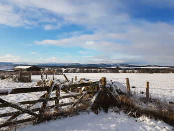 Snow on field against sky during winter